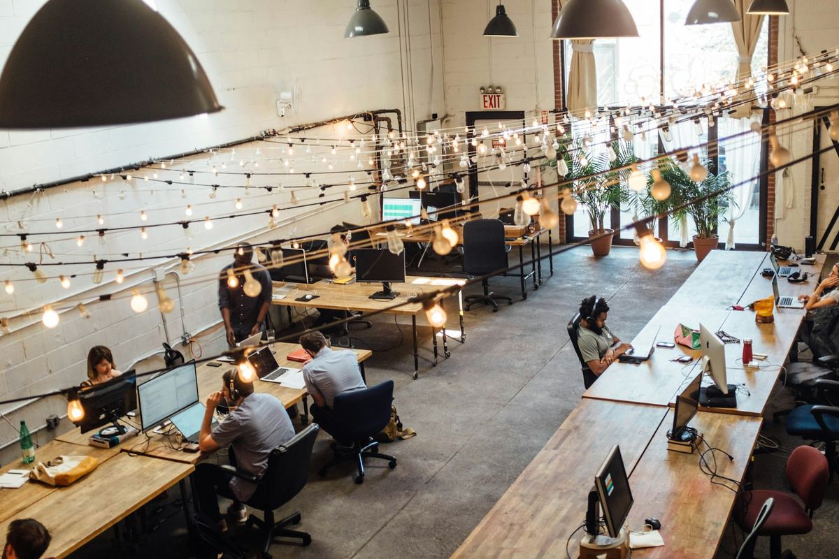 Desks with monitors in a warm co-working room